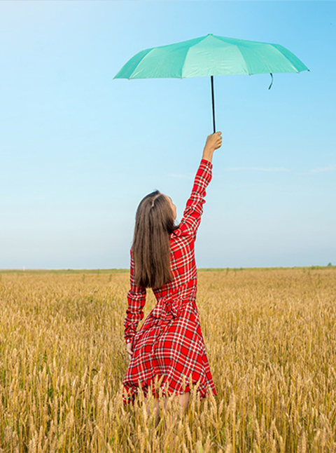 Bright Summer Day: Woman Raising Green Umbrella in Golden Wheat Field